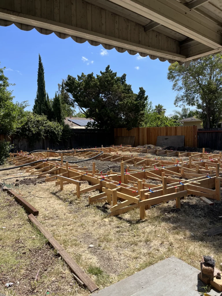 A backyard with a wooden frame under construction.