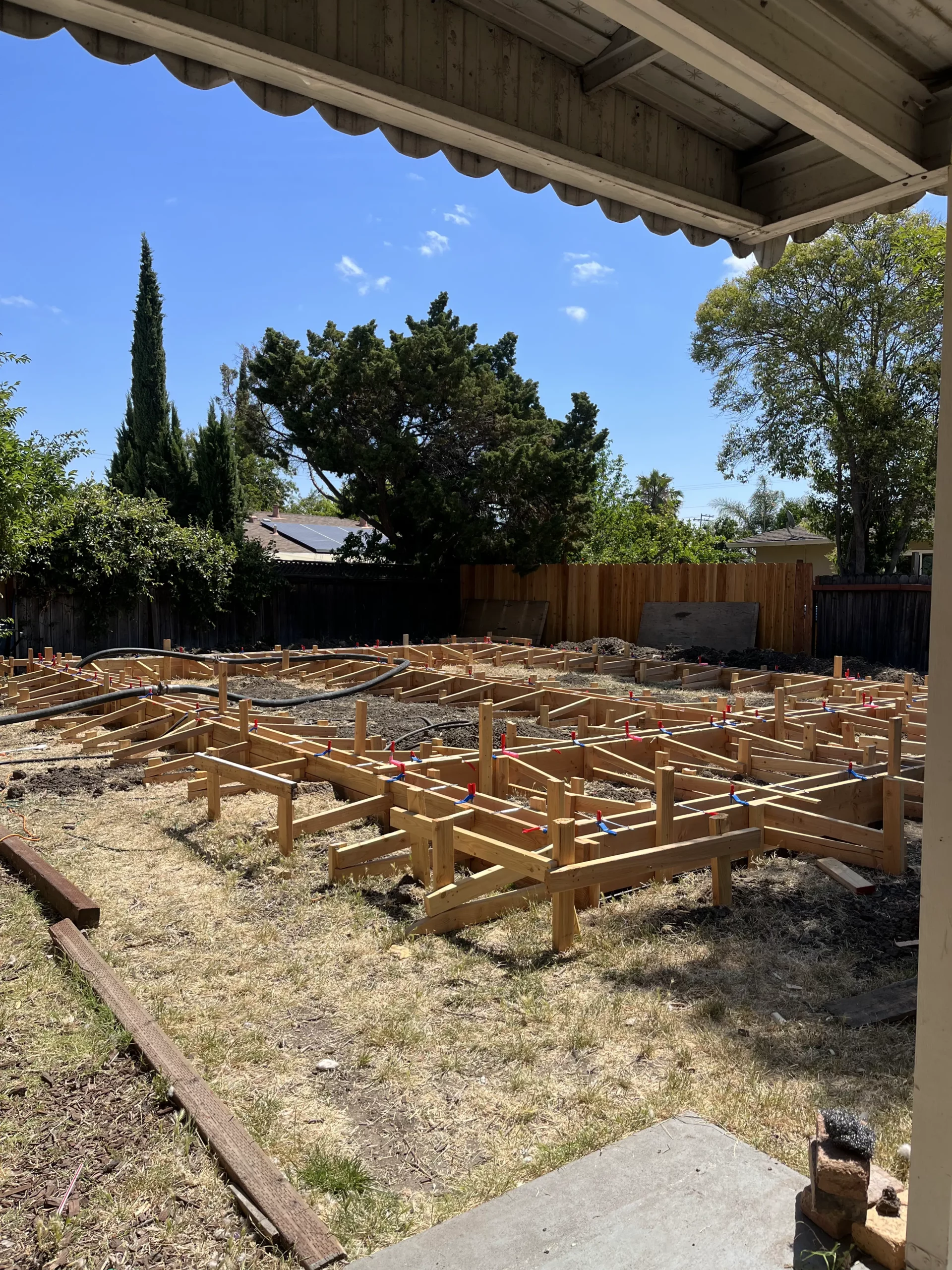 A backyard with wood framing under construction.