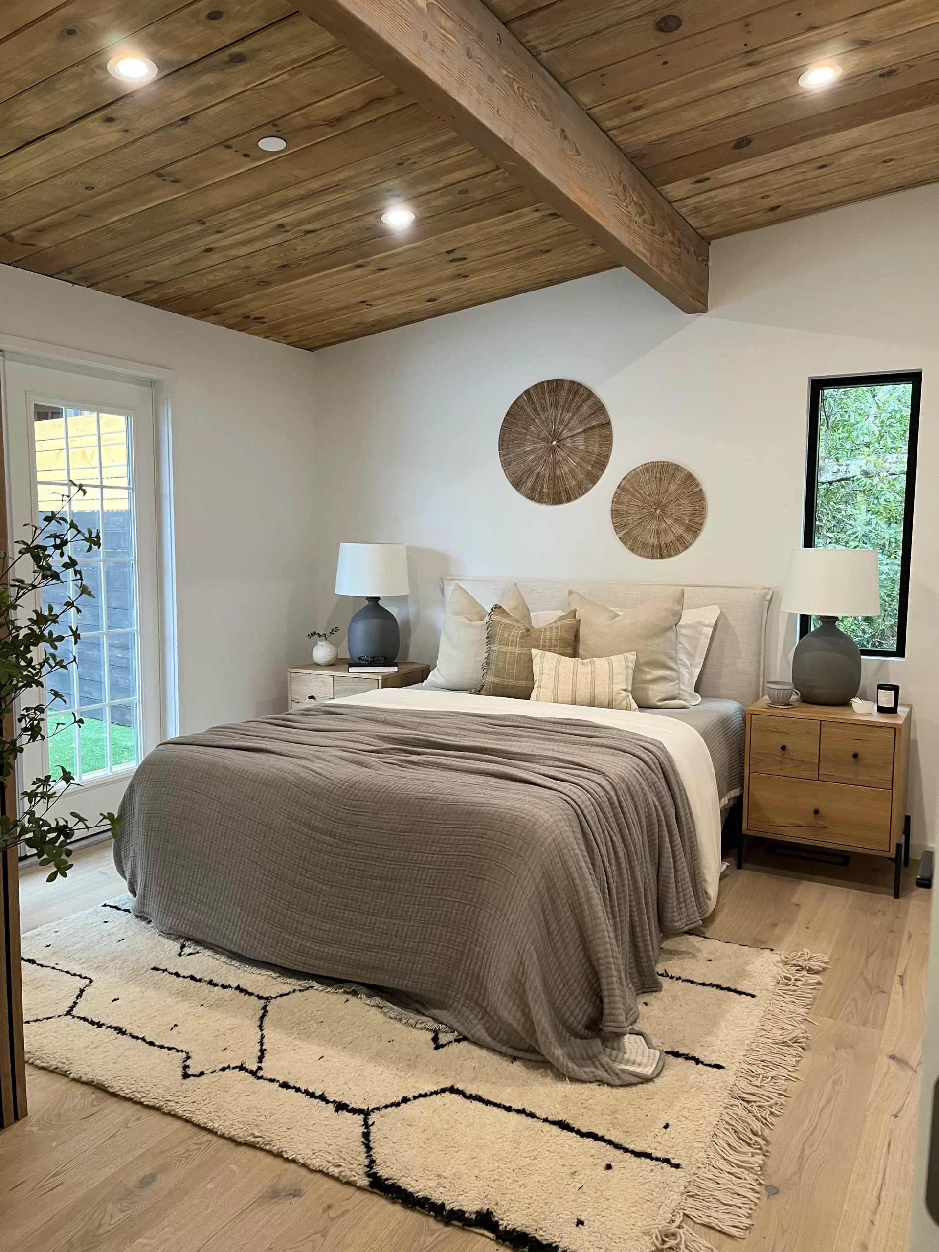 New construction contractor bedroom with wood beams and a white bed.